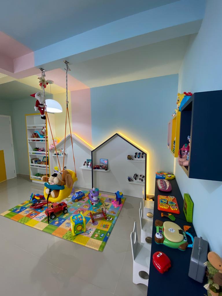 Consultório odontológico infantil com brinquedoteca colorida e balanço
