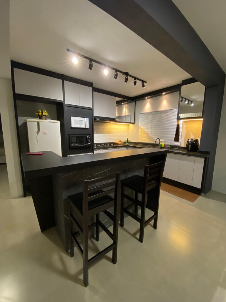 Cozinha com ilha/bancada e banquetas, ambiente executado